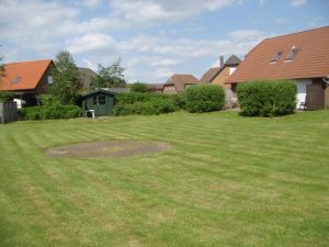 Zwischen den Häusern im Sandboll und Tötel liegt die große Rasenfläche - Bild 13: Nordseeferienhaus Sandboll im Nordseeheilbad Friedrichskoog-Spitze