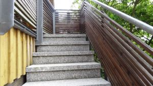 Gut geschützte Treppe mit rauem Natursteinbelag zur Ferienwohnung - oben ein Holztor für unbeschwerten Aufenthalt auf der Loggia - Bild 10: Hundefreundliche komfortable Vier-Sterne-FeWo mit Sauna an der Nordsee