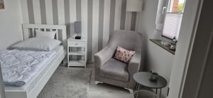 Gemütliches 2. Schlafzimmer renoviert und neuer Boden mit Bett, Nachttisch, KLeiderschrank, Sessel und Tisch - Bild 16: Nordsee Ferienhaus Dornumersiel strandnah - Hund willkommen - WLAN