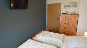 Schlafzimmer mit Doppelbett und Fernseher - Bild 18: Ferienwohnung Bahnkolk II in Norddeich