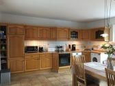 Eine große Küchenzeile mit Geschirrspülmaschine, Kühlschrank, Mikrowelle und Waschmaschine - Bild 1: Ferienhaus Schaumann in Ostfriesland