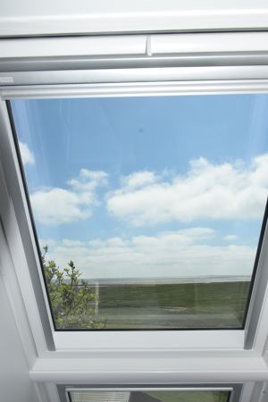 Aus dem Dachfenster auf das Meer und in den Himmel blicken. Gemütlich vor dem Fenster sitzen und den Blick nach Süden mit Wolken und Meer genießen. - Bild 1: Ferienwohnung mit Weitblick auf Hallig Hooge